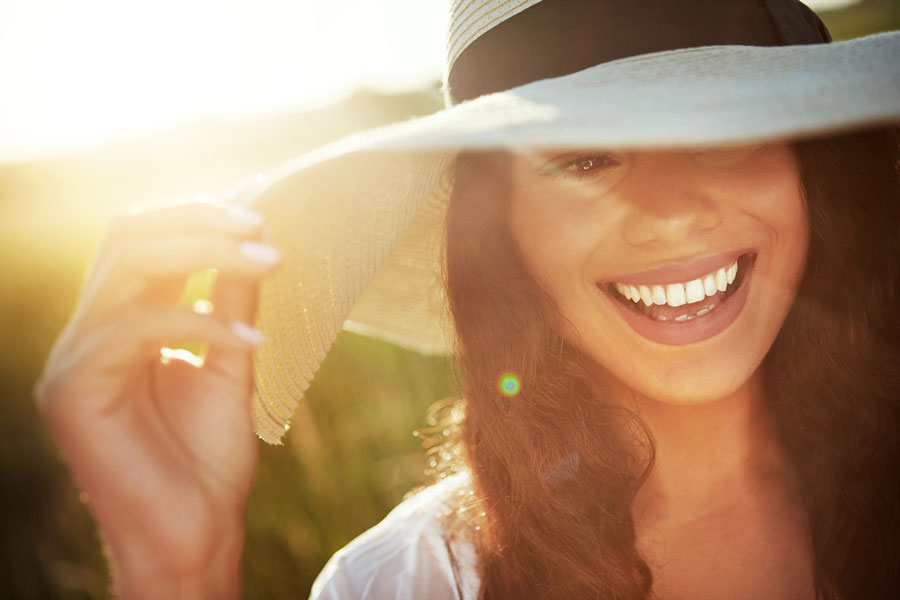 Frau mit Sonnenhut in der Sonne